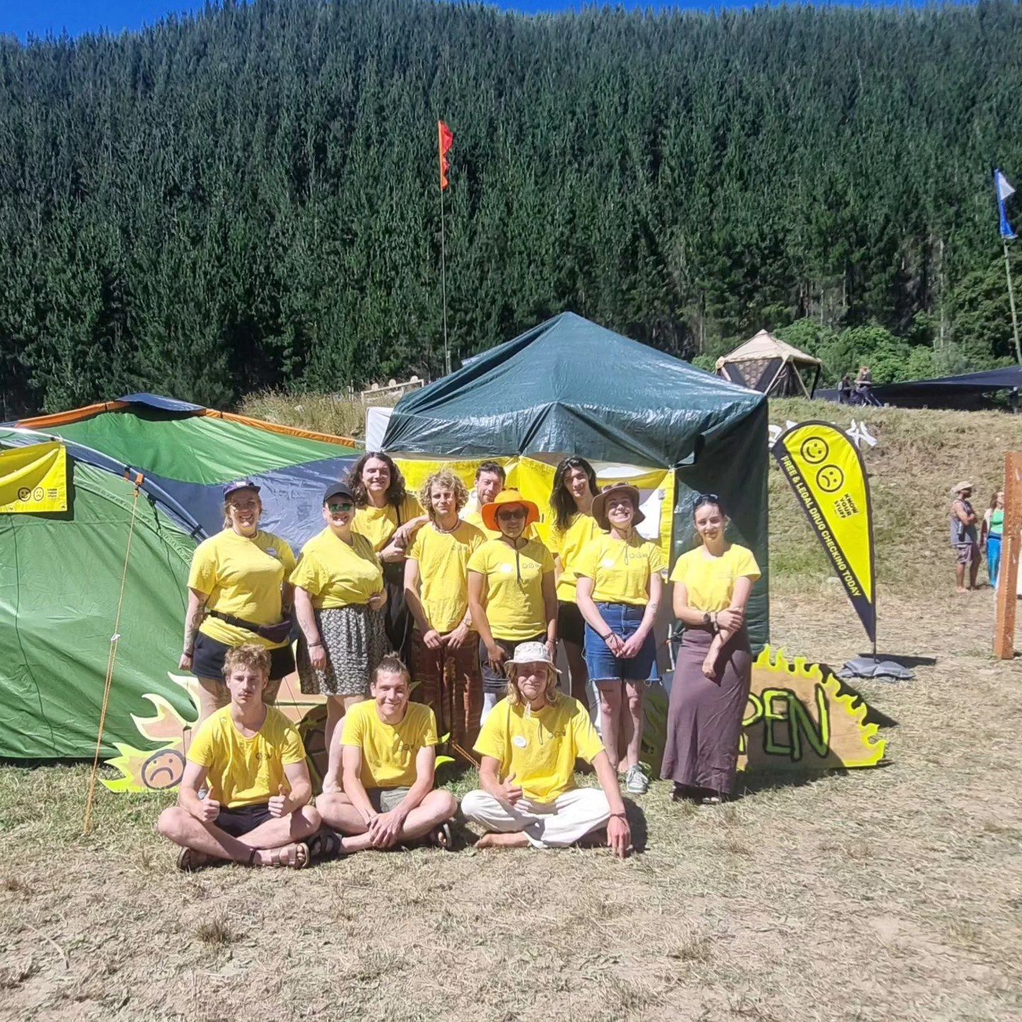 The KnowYourStuff team in the Cobb Valley at Twisted, a group of ten or so people in yellow KnowYourStuff tees in front of a gazebo and tent. A hillside covered with pines stands behind them.